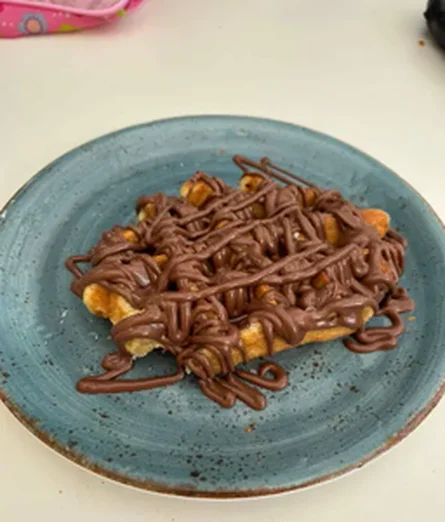 Crepe con chocolate y frutos secos en plato azul